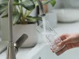 Filling glass of water at kitchen sink.