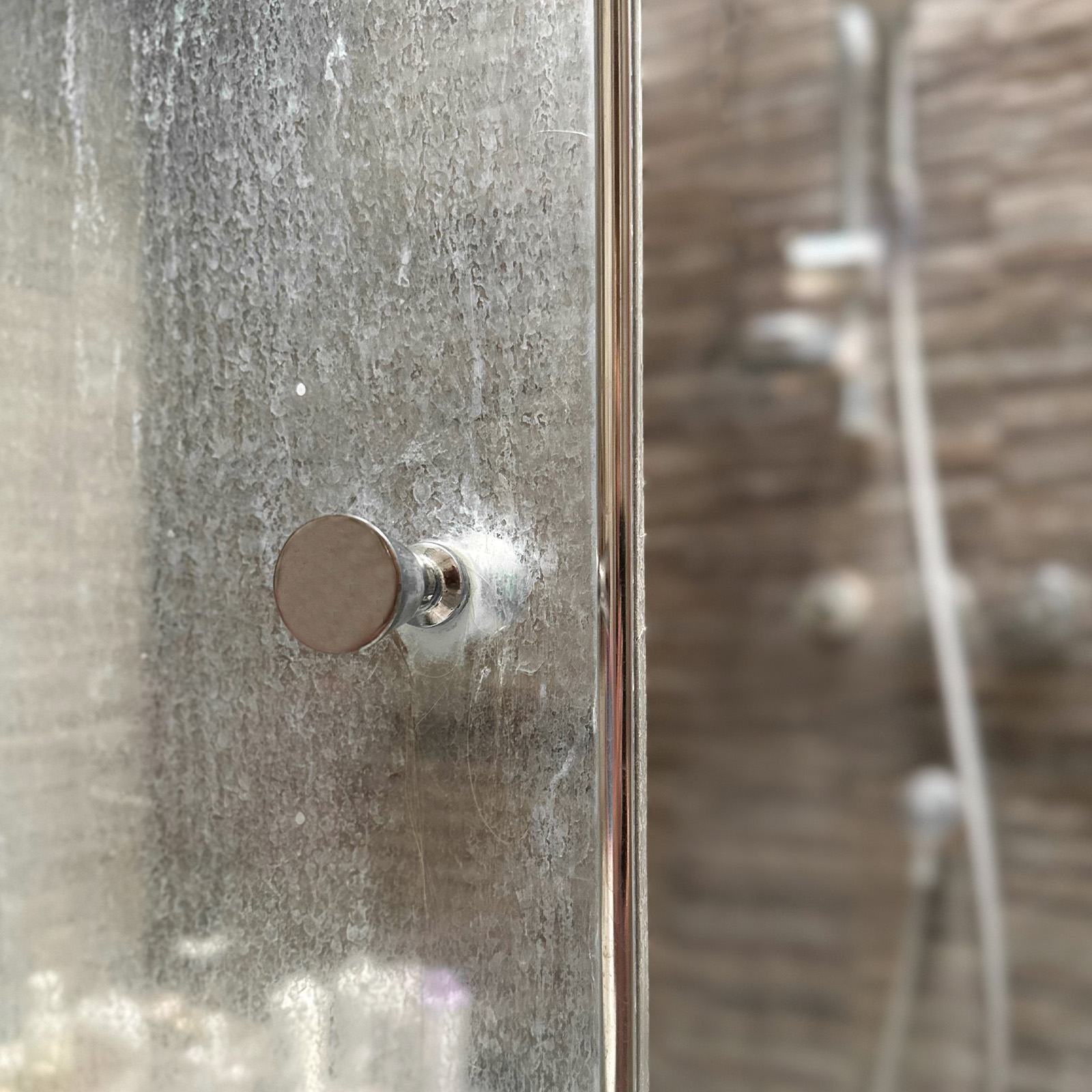 Hard water stains on shower door.