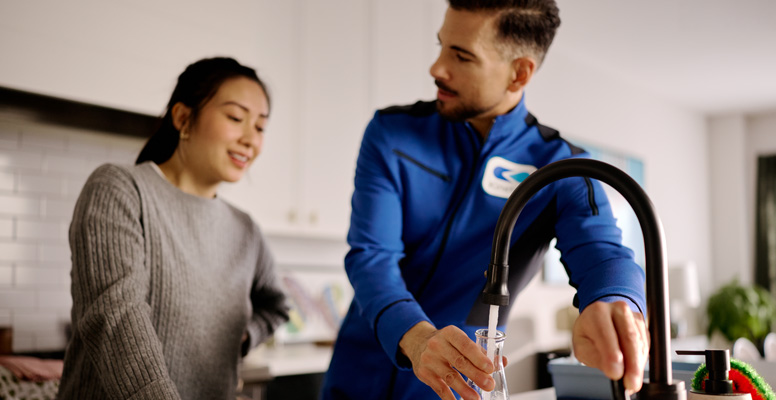 Salesman testing water at kitchen sink.